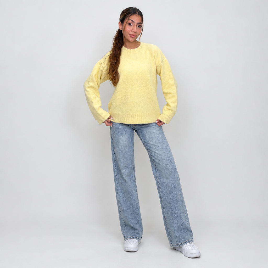 Pastel yellow brushed wool sweater worn with wide leg jeans, full length