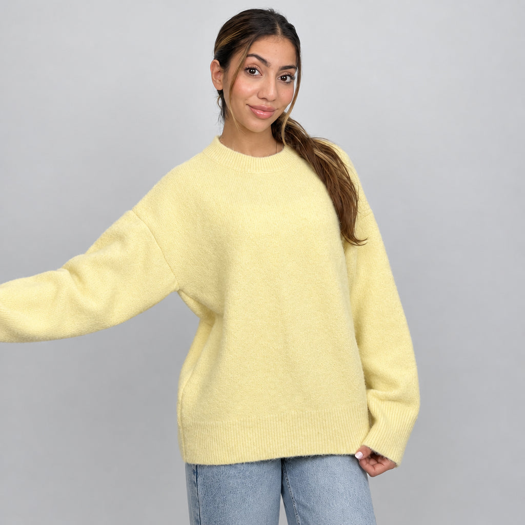 Soft yellow knit sweater shown with one arm outstretched to show the sleeve