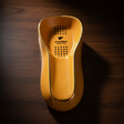 Top view of a yellow elongated cigar ashtray with a gold rim and black dot pattern