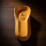 Top view of a yellow elongated cigar ashtray with a gold rim and black dot pattern