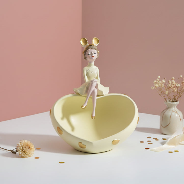 Butter yellow heart dish with gold hearts and a girl in mouse ears seated on its rim