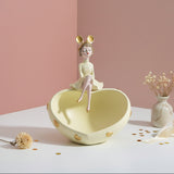 Butter yellow heart dish with gold hearts and a girl in mouse ears seated on its rim
