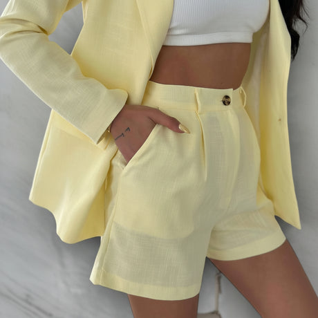 Person wearing a yellow linen outfit with shorts and a jacket