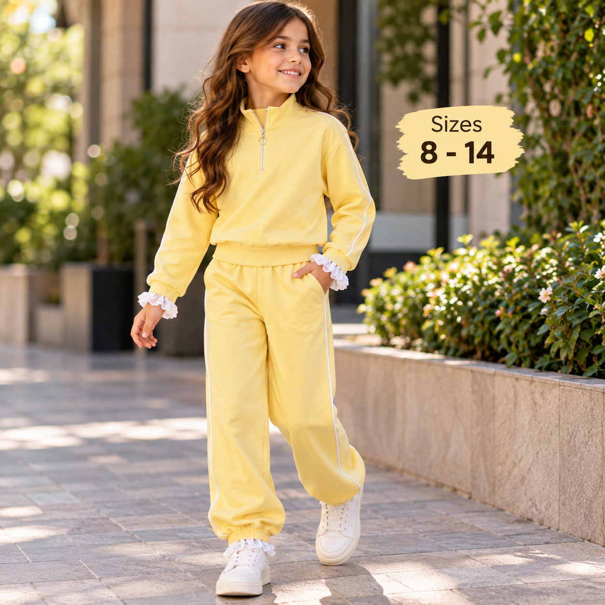 Girl walking in a yellow half zip jogging set with white piping, ruffle cuffs and white sneakers