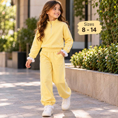Girl walking in a yellow half zip jogging set with white piping, ruffle cuffs and white sneakers