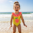 Girl wearing a yellow strawberry print swimsuit on the beach