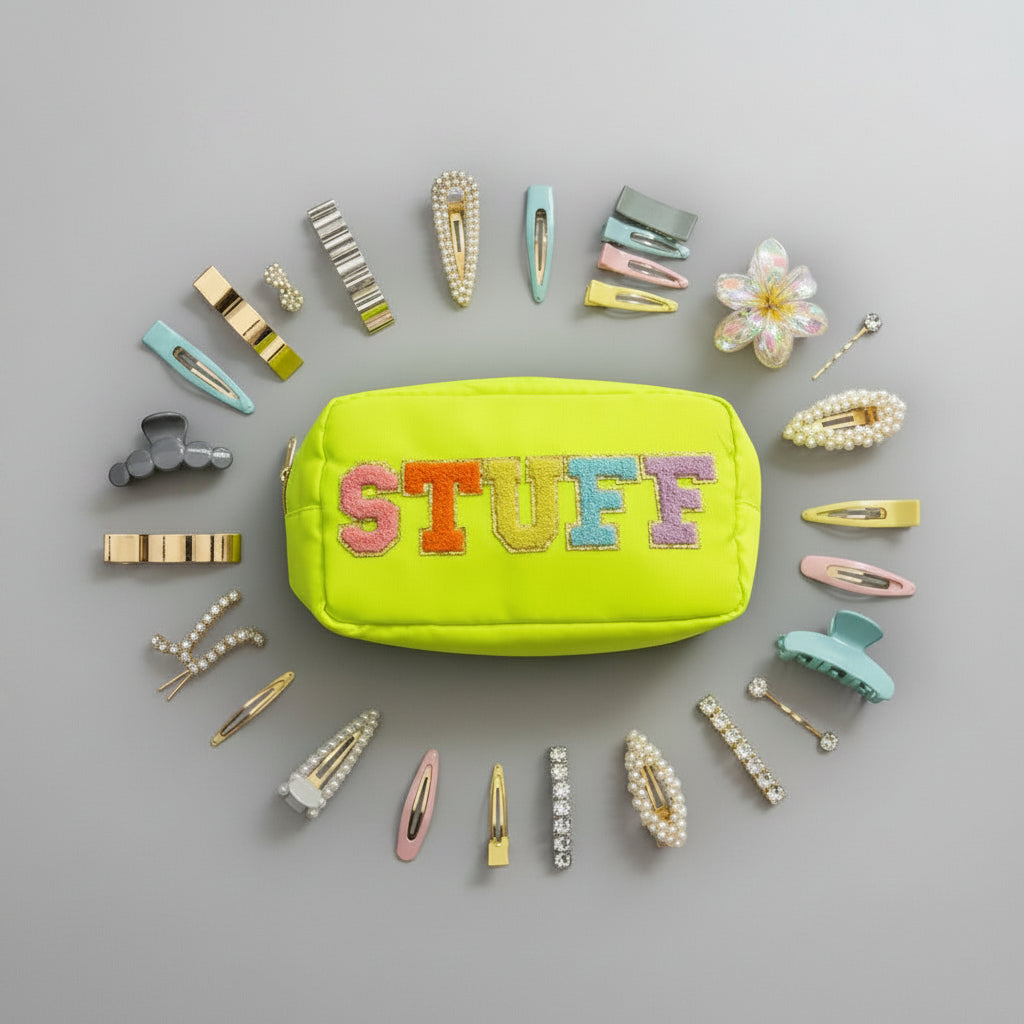 Yellow pouch with 'STUFF' text surrounded by colorful hair clips on a grey background