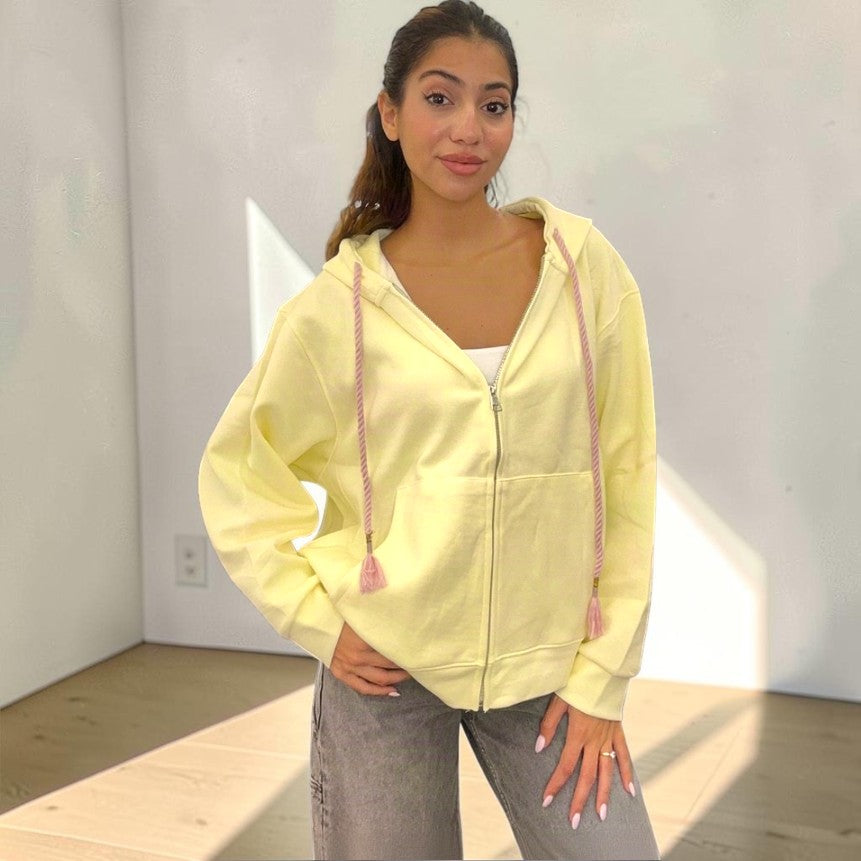 Butter yellow zip hoodie fastened at the front over wide leg grey jeans