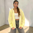 Pale yellow oversized zip hoodie jacket with pink braided tassel drawstrings