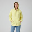 Person wearing a yellow hoodie and blue pants on a grey background