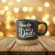 Black mug with 'You are the Best Dad' text on a wooden surface