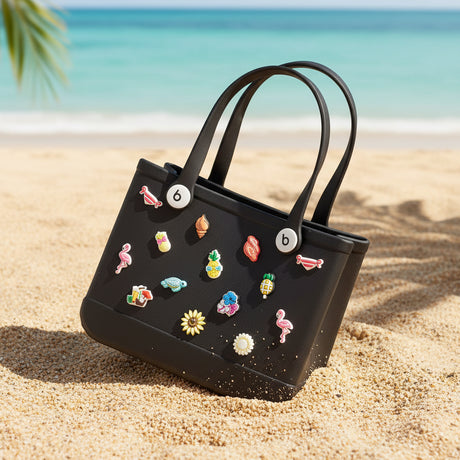 Black handbag with colorful stickers held by a person on a dark surface