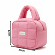 Pink quilted handbag with dimensions on a white background