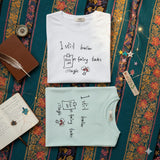 Two shirts with text and graphics on a patterned fabric background