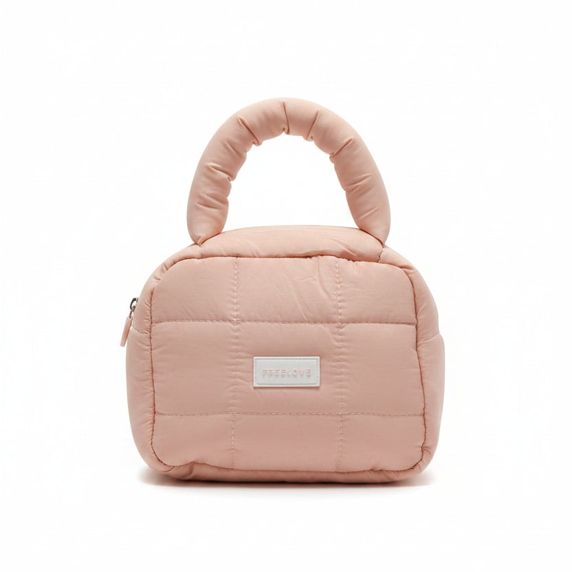 Pink quilted handbag with a visible brand label on a white surface.