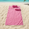 Pink towel with a pillow on the beach