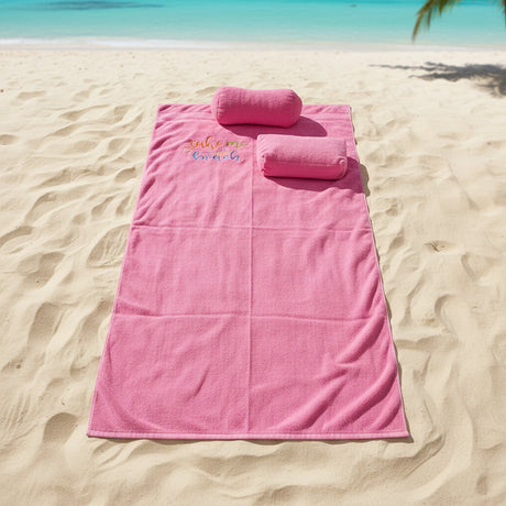 Pink towel with a pillow on the beach