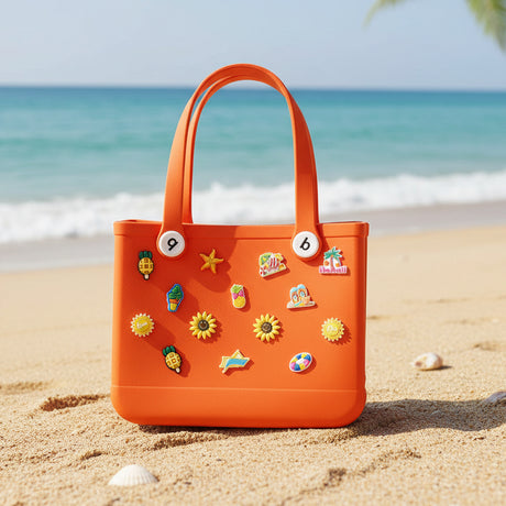 Orange crocs bag with colorful pins on the sand.