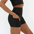 Person wearing black biker shorts on a plain background