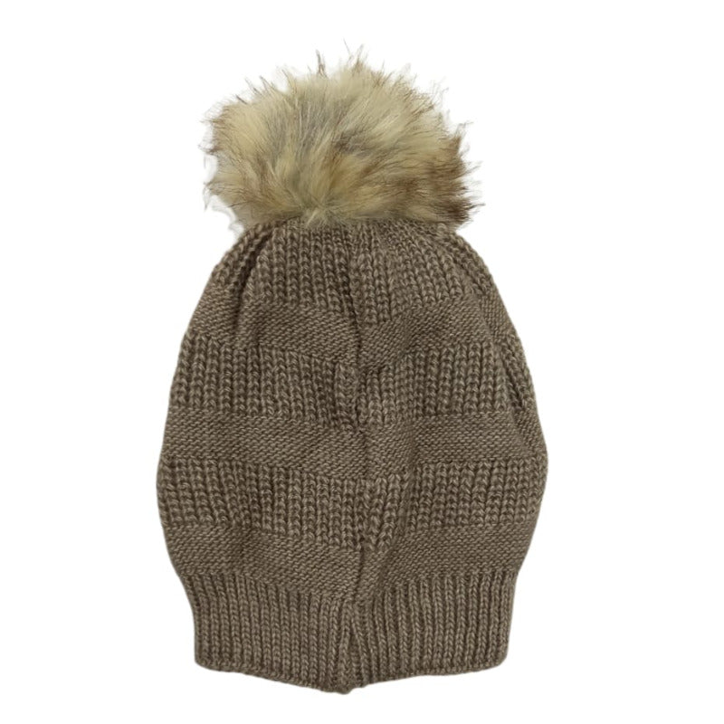 Beanie laid flat on white, showing the cable stitch and fur pom