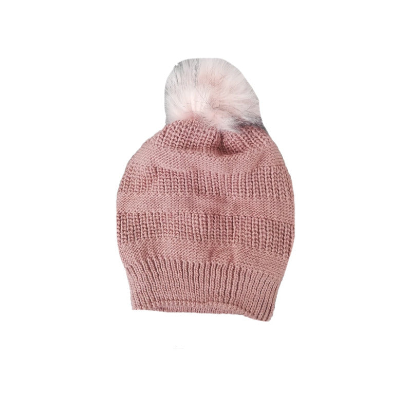 Pink beanie photographed on white, pale pom pom on top